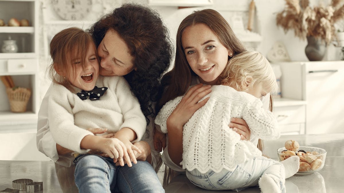 A joyful family gathering in a cozy kitchen with three generations bonded in happiness.
